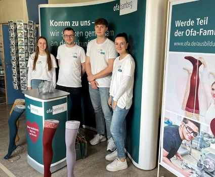 Vier junge Menschen an einem Messestand