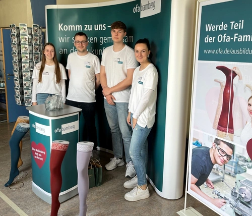 Vier junge Menschen an einem Messestand