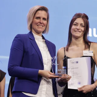 Zwei Frauen mit Trophäe und Urkunde