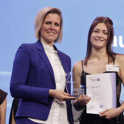 Zwei Frauen mit Trophäe und Urkunde