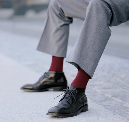 Mann trägt heutzutage auffällige Socken zum Anzug. Bunte Socken wie z. B. von Gilofa 2000 machen angeblich schlau.