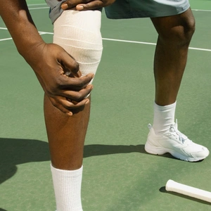 Mann hält sich das schmerzende Knie.