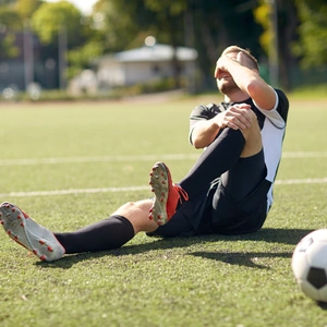 Fußballer hält sich das schmerzende Knie