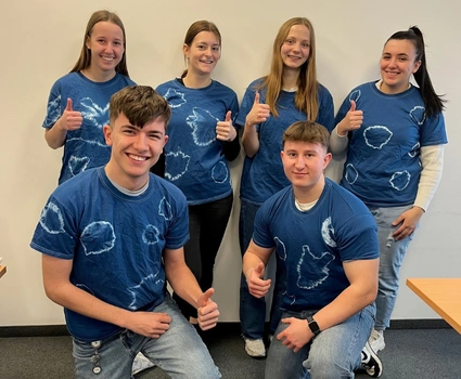 6 Azubis tragen ihre selbst gebatikten T-Shirts in Blau und Weiß.