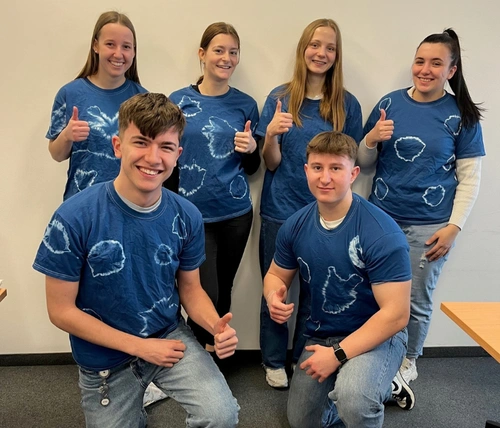 6 Azubis tragen ihre selbst gebatikten T-Shirts in Blau und Weiß.