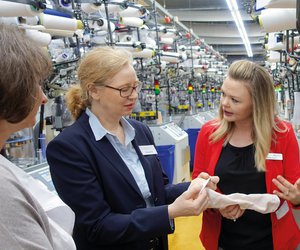 In der Produktion konnte Dr. Anya Miller (Bildmitte) hautnah erleben, wie medizinische Kompressionsstrümpfe hergestellt werden. In der Produktion konnte Dr. Anya Miller hautnah erleben, wie medizinische Kompressionsstrümpfe hergestellt werden.