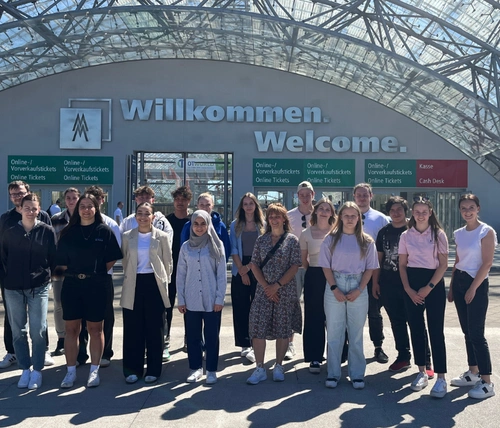 Jugendliche stehen vor dem Eingang zu einem Messegelände