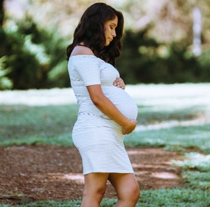 Schwangere Frau hält sich den Bauch