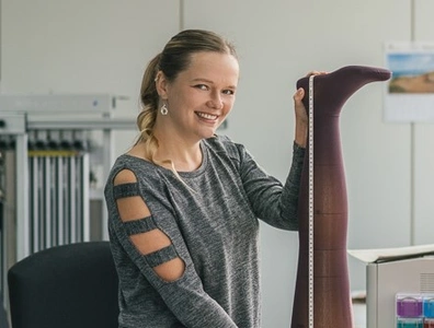 Portraitausschnitt von Frau, die lächelnd Strumpf ausmisst