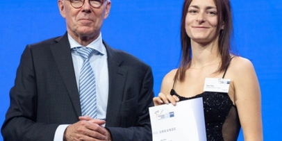 Mann im Anzug und junge Frau mit Urkunde