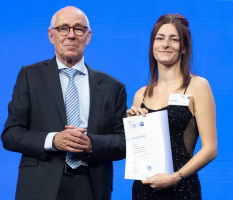 Mann im Anzug und junge Frau mit Urkunde